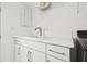 Modern laundry room with white cabinets, stylish hardware, a sink, and sleek countertops at 3280 Juniper Springs St, Wesley Chapel, FL 33543