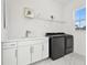 Bright laundry room offers modern washer and dryer, white cabinetry, sink, and stylish marble floors at 3280 Juniper Springs St, Wesley Chapel, FL 33543
