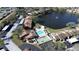 Aerial view of the community with pool, tennis courts, a pond with a fountain, and parking at 3857 Sailmaker Ln, Holiday, FL 34691