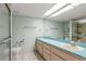 Bathroom with dual sinks, shower stall, and accessible features at 3857 Sailmaker Ln, Holiday, FL 34691