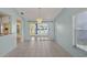Open dining space with view to patio, stylish pendant lighting, and tile flooring at 3857 Sailmaker Ln, Holiday, FL 34691