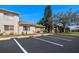 Well-maintained condo exterior with mature landscaping, assigned parking and blue skies at 3857 Sailmaker Ln, Holiday, FL 34691