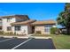 Well-maintained condo exterior featuring nicely landscaped grounds, a parking lot, and an attached garage at 3857 Sailmaker Ln, Holiday, FL 34691