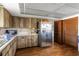 A well-equipped kitchen with rustic wooden cabinetry and stainless steel appliances offers a functional space at 3857 Sailmaker Ln, Holiday, FL 34691