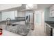 Granite countertops and stainless steel appliances in the kitchen with tile flooring at 3857 Sailmaker Ln, Holiday, FL 34691
