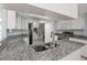 Open kitchen with granite countertops, white cabinets, and a stainless steel refrigerator at 3857 Sailmaker Ln, Holiday, FL 34691