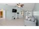 Open-concept living room with tile flooring, ceiling fan, and view of the enclosed back patio at 3857 Sailmaker Ln, Holiday, FL 34691