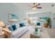 Comfortable living room with white sofa, blue pillows, beach artwork, and ceiling fan at 3857 Sailmaker Ln, Holiday, FL 34691