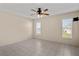 Spacious main bedroom with large windows, ceiling fan and tile flooring at 3857 Sailmaker Ln, Holiday, FL 34691