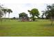 Community playground featuring slides, green lawns, covered picnic area, and mature landscaping for outdoor enjoyment at 3857 Sailmaker Ln, Holiday, FL 34691