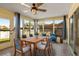 Cozy sunroom with tile floors, dining table, and chairs with blue accents and lots of windows at 3857 Sailmaker Ln, Holiday, FL 34691