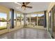 Bright sunroom with tile flooring, ceiling fan, and lots of natural light from the many surrounding windows at 3857 Sailmaker Ln, Holiday, FL 34691