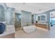 Bright and spacious bathroom with double sinks, soaking tub, marble walls, and ocean view at 4005 Casey Key Rd, Nokomis, FL 34275