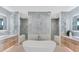 Modern bathroom with marble walls, double sinks, soaking tub, and modern fixtures at 4005 Casey Key Rd, Nokomis, FL 34275