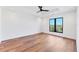 Bright bedroom with hardwood floors, one window offering natural light, and a modern ceiling fan at 4005 Casey Key Rd, Nokomis, FL 34275