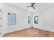 Bright bedroom with hardwood floors, three windows offering natural light, and a modern ceiling fan at 4005 Casey Key Rd, Nokomis, FL 34275