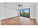 Open bedroom features a ceiling fan, wood flooring and exterior balcony with tree views at 4005 Casey Key Rd, Nokomis, FL 34275