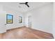 Bright bedroom with hardwood floors, two windows offering natural light, and a modern ceiling fan at 4005 Casey Key Rd, Nokomis, FL 34275