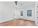 Bright bedroom with hardwood floors, two windows offering natural light, and a modern ceiling fan at 4005 Casey Key Rd, Nokomis, FL 34275