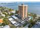Stunning aerial view of a red brick highrise condo building next to a bay with a parking area and pool at 4015 Bayshore Blvd # 11A, Tampa, FL 33611