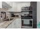 Compact kitchenette featuring stainless steel appliances, light cabinetry, and unique mosaic backsplash at 4015 Bayshore Blvd # 11A, Tampa, FL 33611