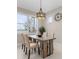 Bright dining room with a view, a modern chandelier, wood table, and cushioned chairs at 42211 Edgewater Dr, Punta Gorda, FL 33982