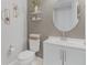 Modern half bath with a white vanity, round mirror, and stylish wall decor at 42211 Edgewater Dr, Punta Gorda, FL 33982