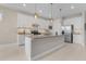 Modern kitchen featuring white cabinetry, stainless steel appliances, and a spacious island with pendant lighting at 42211 Edgewater Dr, Punta Gorda, FL 33982