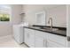 Functional laundry room with white cabinets, dark countertops, and modern appliances at 42211 Edgewater Dr, Punta Gorda, FL 33982