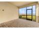 An enclosed patio with brick floors offers tranquil view of the lake and landscaping at 42211 Edgewater Dr, Punta Gorda, FL 33982