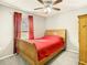 Comfortable bedroom with a wood sleigh bed, red curtains, and neutral gray carpet at 4441 Fieldview Cir, Wesley Chapel, FL 33545