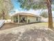 Home exterior featuring a covered patio, fenced-in backyard, and mature trees, perfect for outdoor living at 4441 Fieldview Cir, Wesley Chapel, FL 33545