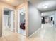 A hallway with tile flooring featuring an open bathroom and bedroom, offering ample space and a well-lit path at 4441 Fieldview Cir, Wesley Chapel, FL 33545