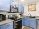 Stylish kitchen with stainless steel appliances, blue cabinets, modern countertops, and a black sink at 4441 Fieldview Cir, Wesley Chapel, FL 33545