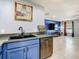 A modern kitchen sink with blue cabinets and stainless steel appliances, open to the spacious living area at 4441 Fieldview Cir, Wesley Chapel, FL 33545