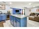 Modern kitchen features blue cabinets, stainless appliances, and large island, flowing into living area at 4441 Fieldview Cir, Wesley Chapel, FL 33545