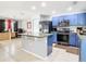 Modern kitchen featuring a central island, stainless steel appliances, and blue cabinetry with tile flooring at 4441 Fieldview Cir, Wesley Chapel, FL 33545