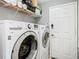 Modern laundry room featuring new washer and dryer units and shelving at 4441 Fieldview Cir, Wesley Chapel, FL 33545