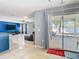 View from kitchen island to living room with sofa, blue accent wall, and outdoor patio at 4441 Fieldview Cir, Wesley Chapel, FL 33545