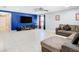 Bright living room featuring a royal blue accent wall, large-screen TV, and cozy sectional, perfect for relaxing and entertaining at 4441 Fieldview Cir, Wesley Chapel, FL 33545