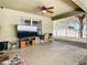 View of a covered outdoor patio featuring a ceiling fan, television, furniture, and grilling area at 4441 Fieldview Cir, Wesley Chapel, FL 33545