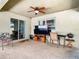 Covered outdoor patio with ceiling fan, television, seating, and grilling area with access to the yard at 4441 Fieldview Cir, Wesley Chapel, FL 33545