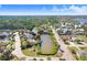 Wide aerial view of single-story house with pond in mature wooded neighborhood at 5510 Berlin Dr, Port Richey, FL 34668