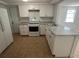 Bright kitchen featuring white cabinetry, stainless appliances, and granite countertops at 5510 Berlin Dr, Port Richey, FL 34668