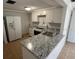 Updated kitchen features white cabinets, granite countertops, stainless steel appliances and an eat in island at 5510 Berlin Dr, Port Richey, FL 34668