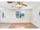 Well-lit living room featuring a large window, ceiling fan, and a mix of tile and wood floors at 5510 Berlin Dr, Port Richey, FL 34668