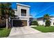 Contemporary two-story home featuring a balcony, attached garage, and a well-manicured lawn at 5934 Maidenstone Way, Palmetto, FL 34221
