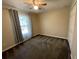 This carpeted bedroom features a ceiling fan, neutral walls, and a window with curtain at 6145 103Rd N Ave, Pinellas Park, FL 33782