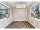 Dining room with wood floors, modern chandelier, paneled walls, and two large windows at 7030 19Th N Way, St Petersburg, FL 33702