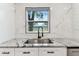 Close-up of a kitchen sink featuring granite countertops, a modern black faucet, and marble backsplash at 7030 19Th N Way, St Petersburg, FL 33702